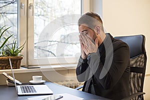 businessman working on laptop in office eyes hurt