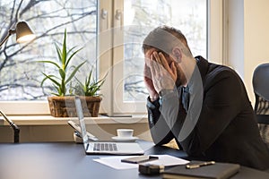 businessman working on laptop in office eyes hurt