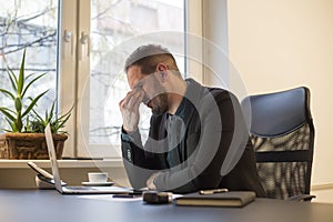 businessman working on laptop in office eyes hurt