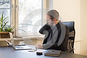 businessman working on laptop in office neck hurt