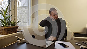 Businessman working on laptop in office neck hurt