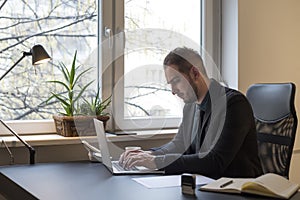 businessman working on laptop in office taking notes