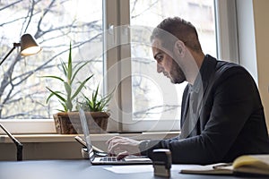 businessman working on laptop in office taking notes