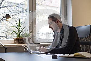 businessman working on laptop in office taking notes