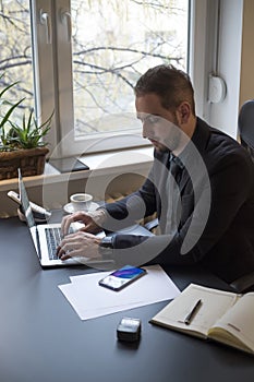 businessman working on laptop in office taking notes