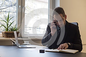 businessman working on laptop in office taking notes