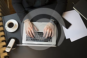 Businessman working on laptop in office taking notes