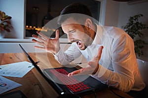Businessman working on a laptop, overworking, under pressure