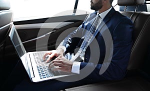 Businessman working with laptop sitting in car
