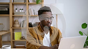 Businessman working with laptop and sitting at table at home during pandemic.