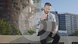 Businessman working on laptop at street. Freelancer using computer outside