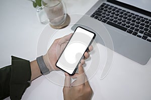 Businessman working with laptop and using smart phone at office desk.