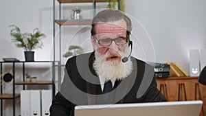 Businessman working on laptop wearing headset, call center support service operator office helpline