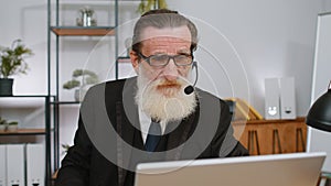 Businessman working on laptop wearing headset, call center support service operator office helpline