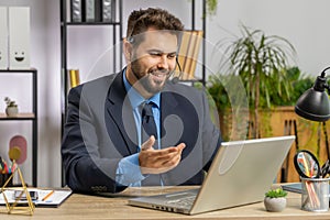 Businessman working on laptop wearing headset, call center support service operator office helpline