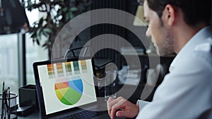 Businessman working on laptop at workplace. Man using touchpad on laptop