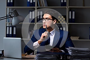 The businessman working late at night in office for overtime bonus