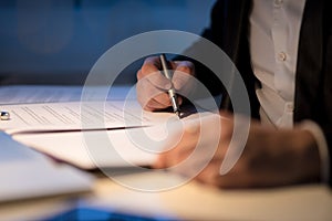 Businessman working late signing a document or contract