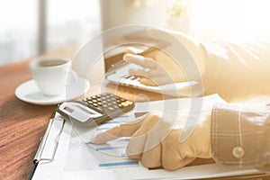 Businessman working with modern workplace with laptop on wood table, Man hand on laptop keyboard for work from home, Overhead view