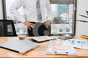 Businessman working on office desk, looking tired