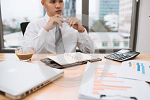 Businessman working on office desk, looking tired