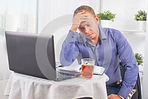 Businessman working in office, sitting at table with a laptop fr