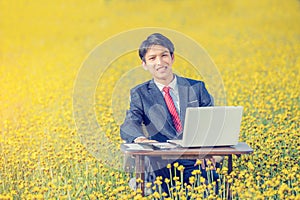 Businessman working outdoor in yellow field