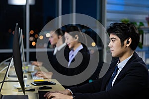 Businessman working overtime late at night in call center office with colleague team