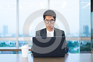 A businessman is working seriously with his laptop computer.