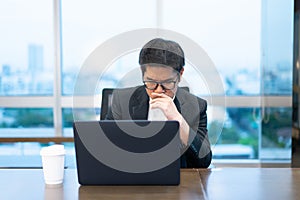 A businessman is working seriously with his laptop computer.