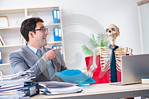 The businessman working with skeleton in office