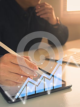 Businessman working with statistics, looking at laptop and phone screens