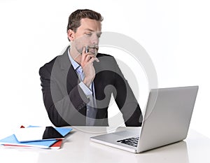 Businessman working in stress at office desk computer laptop reflexive and doubtful pensive and thoughtful