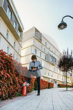 Businessman working with the tablet in the street