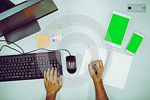 Businessman working by using computer and also taking memo on notebook
