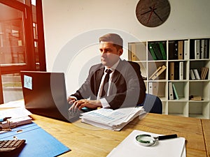 Businessman works at the computer in the office. A man is typing on a laptop