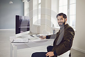 Businessman works at the computer at the table in the workplace in the office