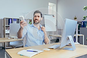 Businessman works during the day in a modern office, man holds hot air conditioner in his hands, reduces air temperature