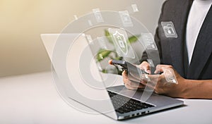 A businessman works on his laptop at home with a virtual display showing a symbol to signify cyber security privacy and online