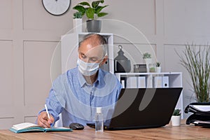 Businessman works in the office in a medical mask for coronavirus protection. New normal business practise of coronavirus covid-19