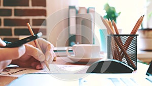 Businessman works with a smartphone and checking financial report and charts in the office at workplace.