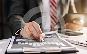 Businessman writes information businessman working on laptop computer writing business plan.