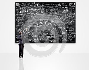 Businessman writing on blackboard with business plan