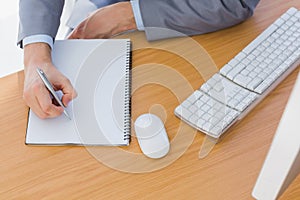 Businessman writing on blank notepad