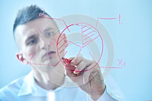 Businessman writing business pie chart on transparent screen