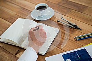 Businessman writing on a diary