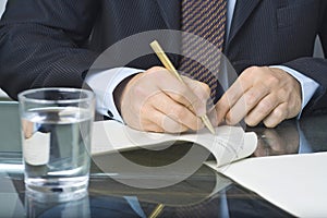 Businessman writing in a document