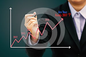 Businessman writing Estimate graph for year 2017 (Pastel tone).