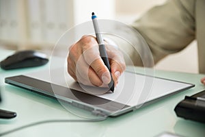 Businessman writing on graphic tablet