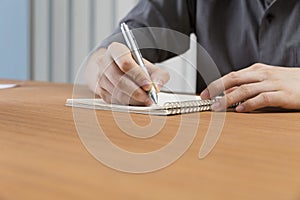 businessman writing note on notepad